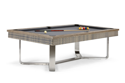 The Bali Slate Pool Table by Brunswick Billiards is displayed on a crisp white background, showcasing its sleek stainless-steel base, hand-polished teak rails, and artisan-woven wicker aprons. The vibrant Sunbrella felt creates a striking contrast, emphasizing the table’s customizable design and professional-grade craftsmanship.