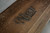 Close-up of the laser-engraved Nixon Billiards logo on the end rail of the Hunter Pool Table in Brushed Walnut. This image highlights the premium craftsmanship and attention to detail, with the logo adding a distinctive touch of authenticity to the table’s elegant design.
