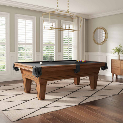 The Carrigan Billiard Table is styled in a modern game room, with natural light highlighting the rich wood finish and clean apron. This setting shows how the table anchors a room and blends luxury with everyday functionality.