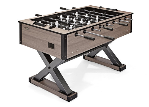 A clean, wide-angle shot of the Brunswick Premier Foosball Table showcased on a white background. The steel “X” frame legs contrast with the weathered oak finish, giving the table a sleek, modern industrial look. The rods and handles are in their neutral position, hinting at the fun, competitive matches to come.