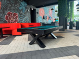The X-Air 8' Outdoor Custom Slate Pool Table in an upscale outdoor entertainment area. Featuring stainless steel hardware and Sunbrella fabric, the table blends effortlessly with the modern outdoor lounge, offering a sophisticated game experience in an open-air setting.