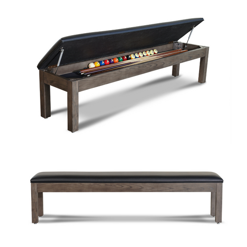 The Nixon Billiards Storage Bench is shown with the cushioned seat fully open, revealing its internal storage space neatly organized with 8 cue sticks and the Sawyer Twain Trophy Kit ball set. The cues are arranged side by side beneath the hinged lid, with the full set of premium pool balls securely stored in the dedicated compartment. The black synthetic leather upholstery and solid hardwood frame in Weathered Natural finish create a sleek, functional presentation. This image captures both practicality and polish—designed for high-end game rooms and exclusively available at Sawyer Twain.